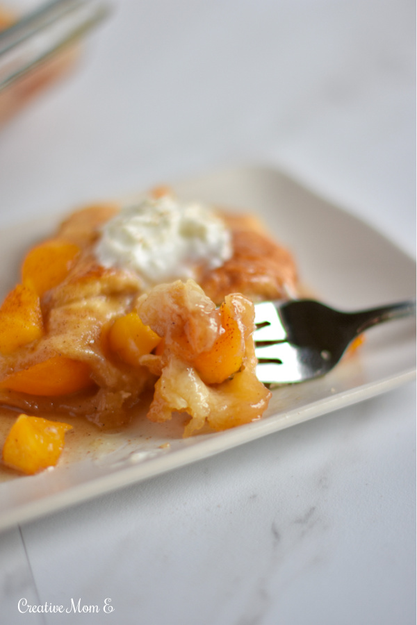 Fork on a plate with peach cobbler.