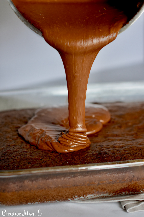 Fudge chocolate frosting being poured onto of the Sinfully Rich Chocolate Cake.