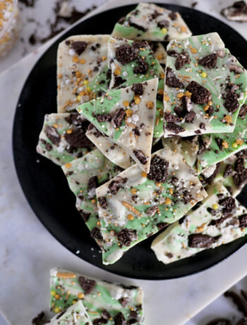 Cookies and Cream Chocolate Bark on a black plate with Oreo crumbs.