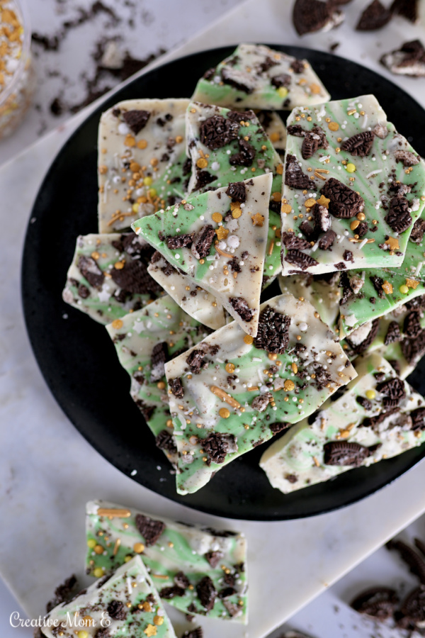 Cookies and Cream Chocolate Bark on a black plate with Oreo crumbs.