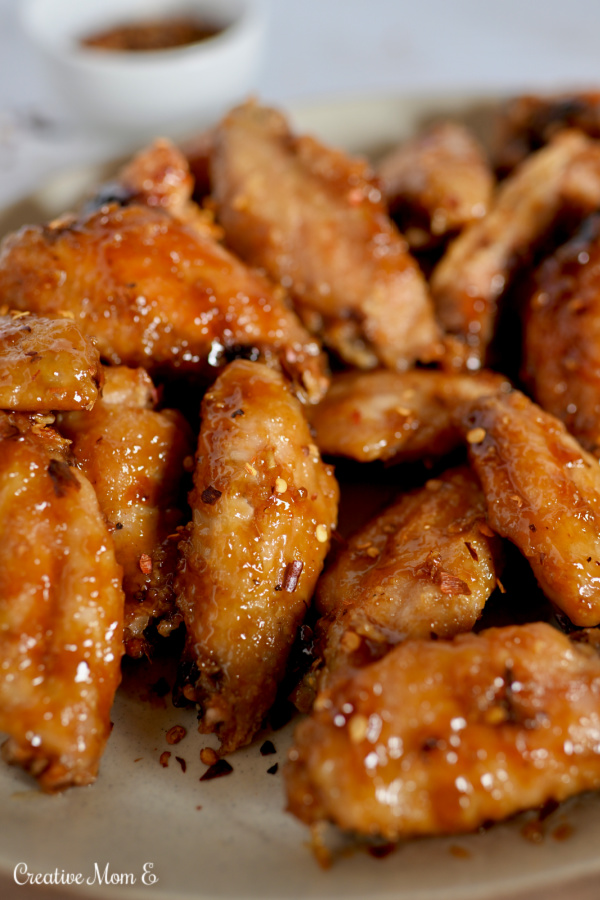 Chicken wings with crunchy skin sprinkled with red pepper flakes.