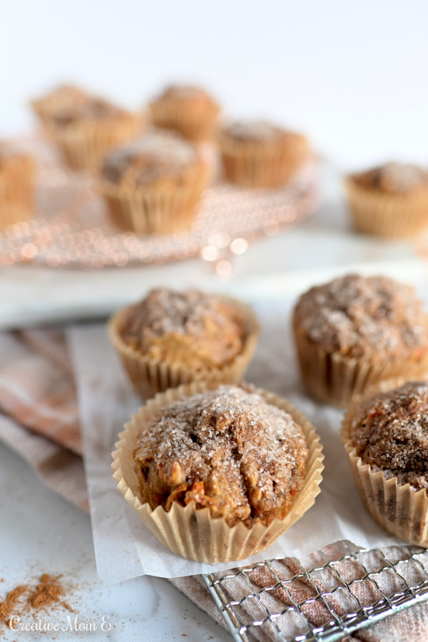Carrot Muffins topped on cinnamon sugar on parchment paper and a wire rack. 