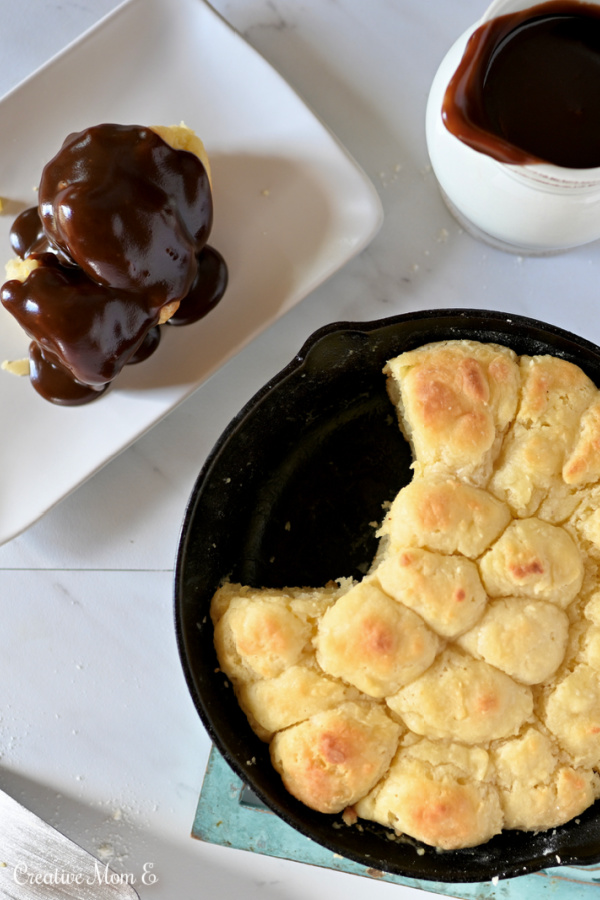 Skillet with biscuits next to a plate with chocolate gravy covered biscuits.