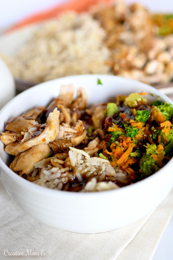 A white bowl of chicken and broccoli with teriyaki sauce drizzled on top.
