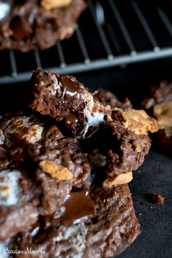 Gooey Fudge Chocolate Cookies stacked on each other on a black countertop 