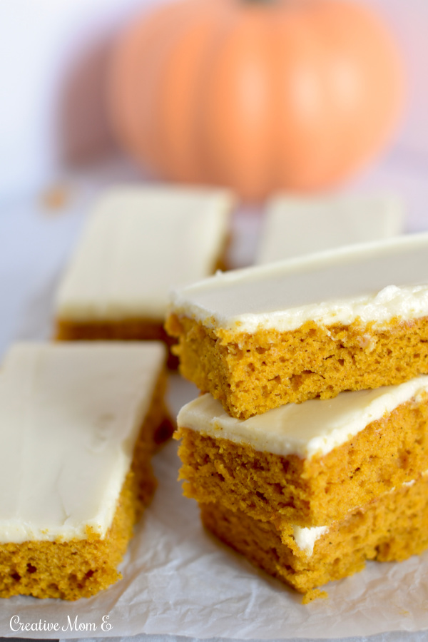 Cream Cheese Pumpkin Bars stacked on top of each other. 