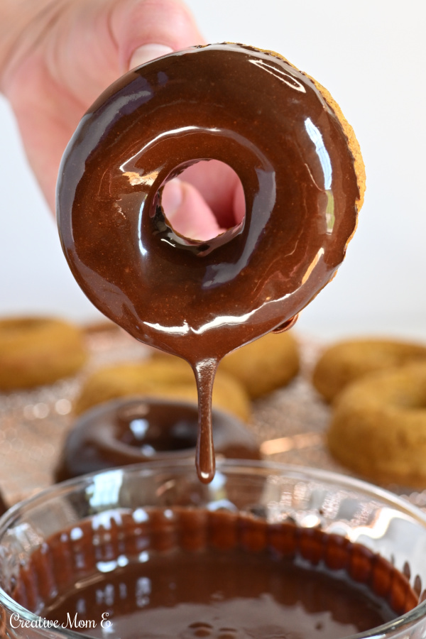 Freshly dipped easy baked pumpkin donuts in a cinnamon chocolate glaze. 